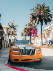 orange car parked on sidewalk during daytime